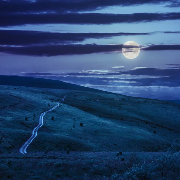 Strada attraverso un prato sulla collina di notte — Foto Stock