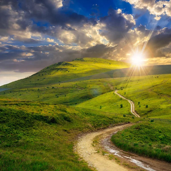 Bergpad bergop naar de hemel bij zonsondergang — Stockfoto