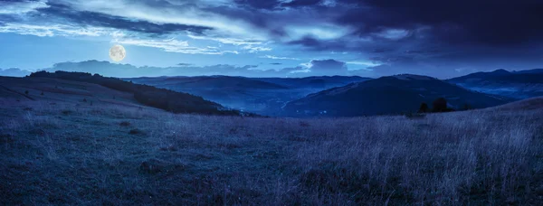 Valle in montagne su pendio sotto il cielo con nuvole di notte — Foto Stock