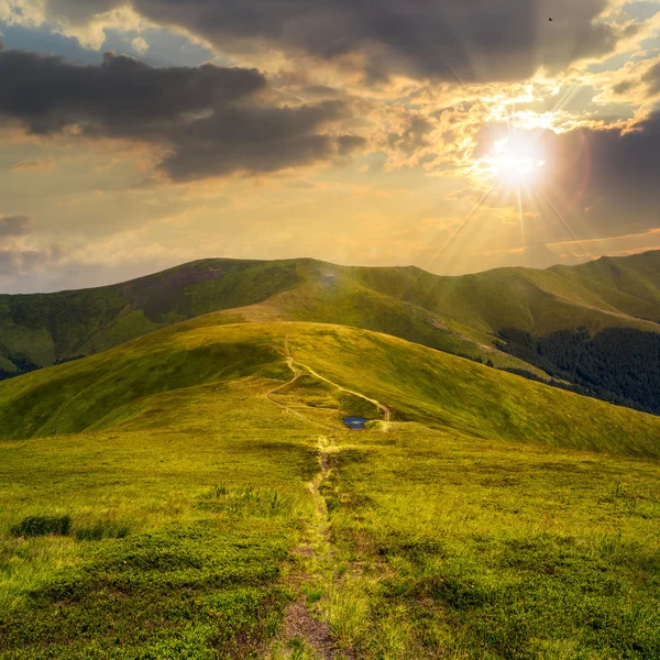 Piccolo lago su una collina verde al tramonto — Foto Stock