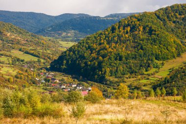 Dağlardaki kırsal alan. bulutlu sonbahar havası. Uzak vadideki köy