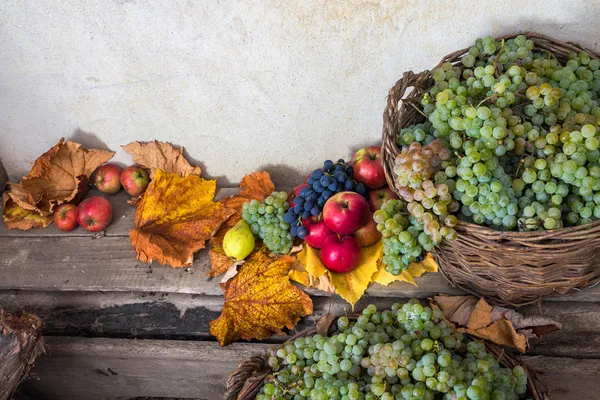 Herbstliches Stillleben mit Früchten und Blättern auf Holzsockel — Stockfoto