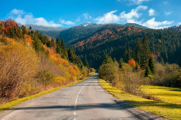 山中的乡村道路 美丽的秋天风景 阳光灿烂的早晨 沿路生长着五彩缤纷的树叶 天上飘扬的云彩在遥远的山顶之上 旅行回国的概念 — 图库照片