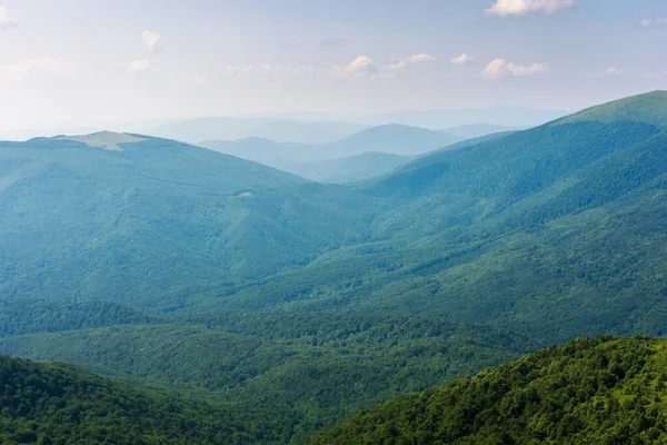 Dağ manzarası çok güzel. Yeşil çim çayırlarındaki taşlar ve kayalar. Güzel yaz doğası arka planı akşam ışığında. Manzaralı vadi manzarası. Bulutlu gökyüzü