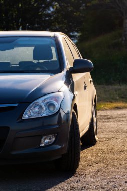 Hatchback sabah vakti açık hava otoparkında. Küçük araç detayı bulutlandı. Kiralık araba. yaz tatili konsepti