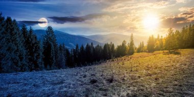 Gece ve gündüz, kozalaklı ormanlarla manzara üzerinde konsept değiştiriyor. Alacakaranlıktaki güzel doğa manzarası. Sonbaharda gökyüzünde güneş ve ay olan harika Karpatya dağ manzarası