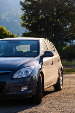 Hatchback sabah vakti açık hava otoparkında. Küçük araç detayı bulutlandı. Kiralık araba. yaz tatili konsepti