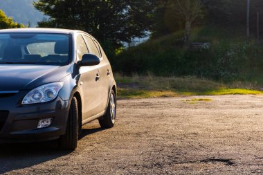 Hatchback sabah vakti açık hava otoparkında. Küçük araç detayı bulutlandı. Kiralık araba. yaz tatili konsepti