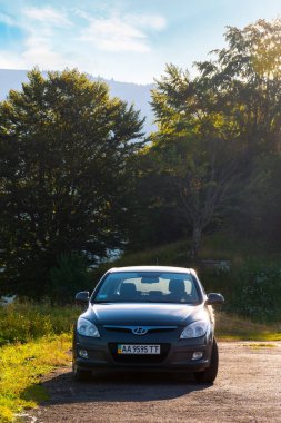 Mizhirya, Ukrayna - AUG 08, 2020: araba ormanın yakınına park etti. Sabah ışığında güzel doğa manzarası. Araba konseptiyle seyahat. Küçük bir hatchback 'te yaz maceraları