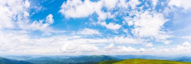 Öğlen vakti kabarık bulutlu gökyüzü manzarası. Dağ sırtının tepesindeki bulutlar çok güzel. Güneşli bir günde yaz doğası.
