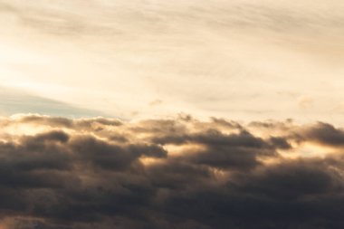 Altın saat ışığında gökyüzünde bulutlar. Yazın gün batımında sıcak hava