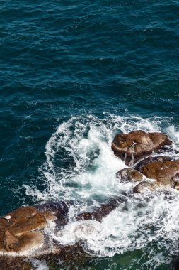 Denizde kayalar. Dalgalar kıyıya çarpıyor. Su ve taş dokusu. yaz doğa arka planı