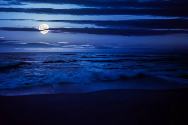 밤에는 파도는 보름달이 비추는 모래사장을 방학에 벨벳의 구름들 — 스톡 사진