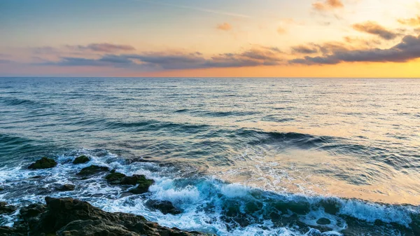 calm morning at the sea. nature scenery with rocky coast at dawn. clouds glowing on the sky. scenic picture-postcard view. black sea, bulgaria, europe