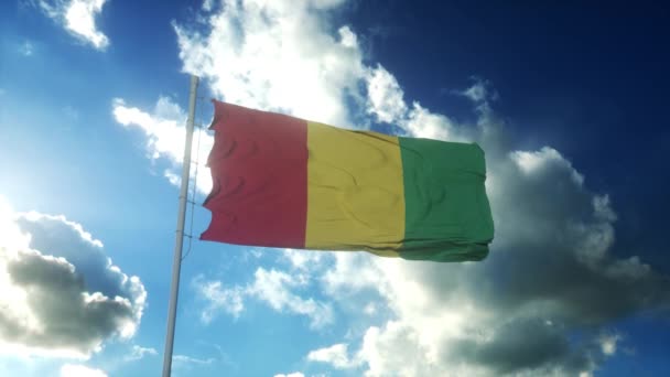 Guinejská vlajka vlnící se proti větru proti krásné modré obloze — Stock video