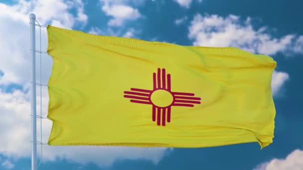 Флаг Нью-Мексико на флагштоке, машущем на ветру, голубом фоне неба — стоковое видео