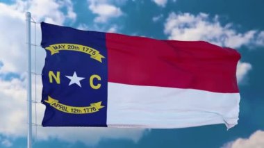 Kuzey Carolina bayrağı dalgalanan bir bayrak direğinde, mavi gökyüzü arka planında