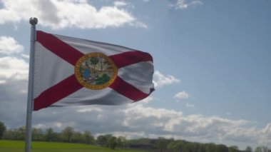 Florida bayrağı gökyüzünde dalgalanan bir bayrak direğinde. Florida Eyaleti Amerika Birleşik Devletleri