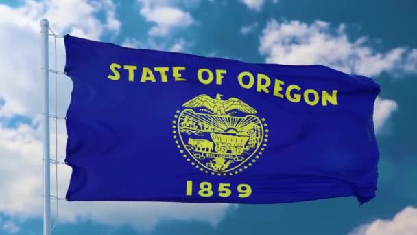 Oregon Flagge auf einem Fahnenmast weht im Wind, blauer Himmel Hintergrund — Stockvideo