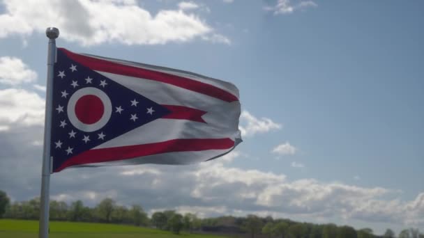 Flaga Ohio na maszcie flagowym na wietrze, niebieskie tło nieba — Wideo stockowe