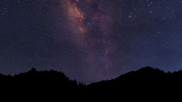 Gece vakti doluyor. Yıldızlı gece geçmişi. Samanyolu Galaksisi dağ sırtından geçiyor. — Stok video