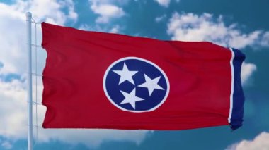 Rüzgarda dalgalanan bayrak direğinde Tennessee bayrağı, mavi gökyüzü arka planı.