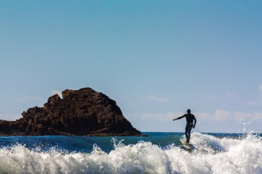 Surfer Comes Ashore at Leo Carrillo State clipart