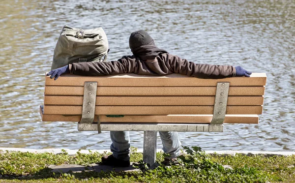 Człowiek śpi na ławce w parku — Zdjęcie stockowe