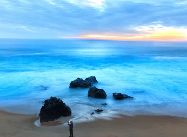 Man Photographing Crashing Waves ao pôr do sol com telefone móvel — Fotografia de Stock