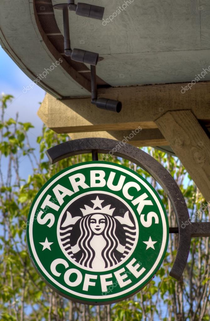 Starbucks sign in at Starbucks Coffee shop sign. Starbucks is an American global coffee company and coffeehouse chain based in Seattle, Washington.