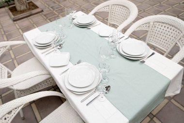 Bardaklar, çatallar, bıçaklar akşam yemeği için servis edilen sıcak bir restoranda.