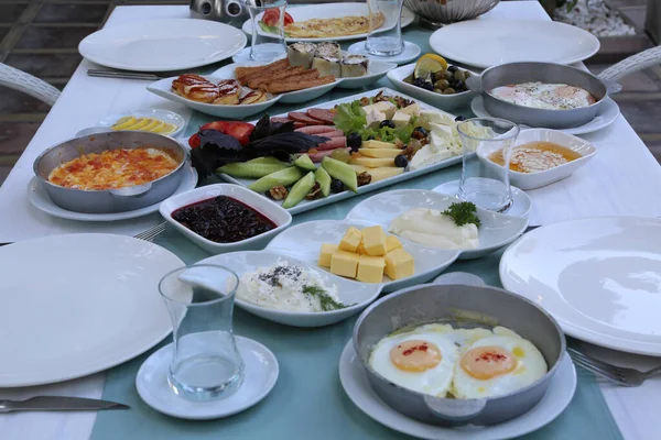 Organik, taze geleneksel Türk köyü kahvaltısı ahşap masada bakır yumurta tavasıyla.