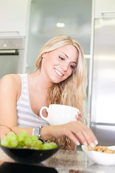 Young beautiful woman enjoying healthy breakfast in the kitchen — Stock Photo, Image
