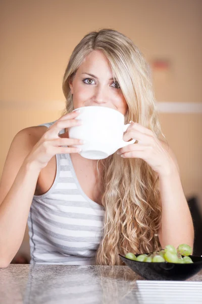 Joven hermosa mujer disfrutando de un desayuno saludable en la cocina — Foto de Stock