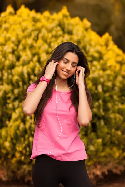 Jonge mooie vrouw met hoofdtelefoon buiten genieten — Stockfoto