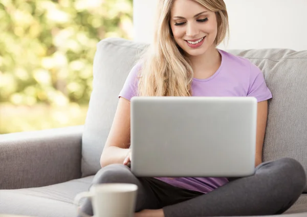 Jovem mulher bonita usando um laptop em casa — Fotografia de Stock