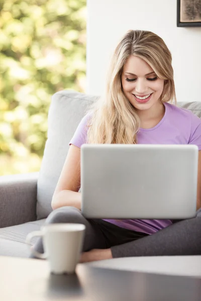 Ung vacker kvinna som använder en bärbar dator hemma — Stockfoto