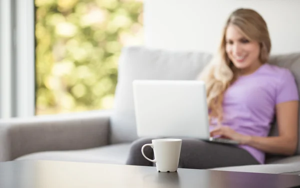 Jovem mulher bonita usando um laptop em casa — Fotografia de Stock