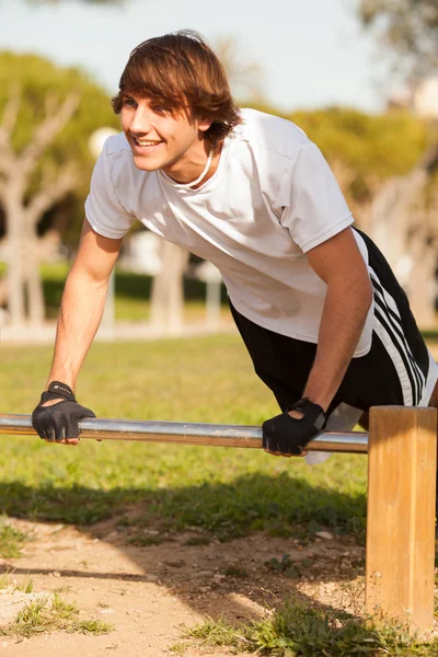 Genel bir parkta genç sağlıklı bir insan yapımı egzersiz — Stok fotoğraf