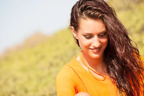 Porträtt av unga vackra kvinnan skrattar klädd i orange tröja — Stockfoto