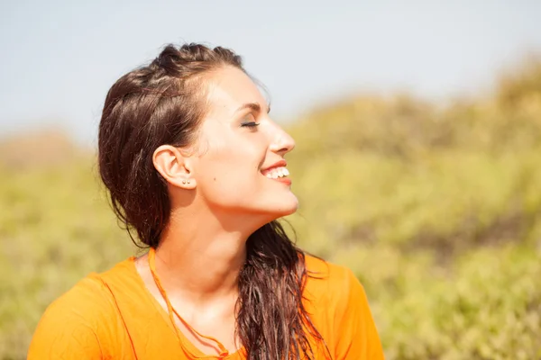 Портрет молодой красивой женщины, смеющейся в оранжевой рубашке — стоковое фото