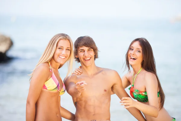 Tres jóvenes hermosos amigos divirtiéndose en la playa — Foto de Stock