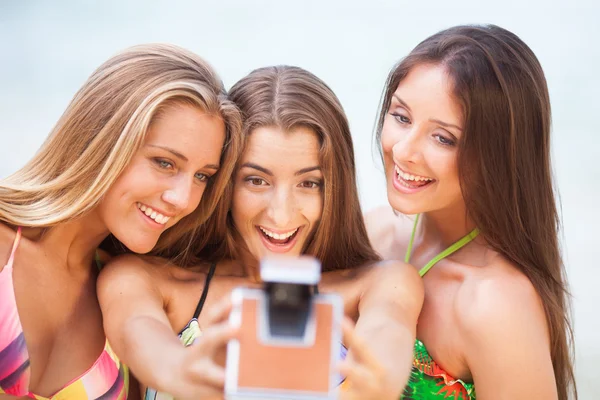 Três jovens belas namoradas se divertindo na praia com um — Fotografia de Stock