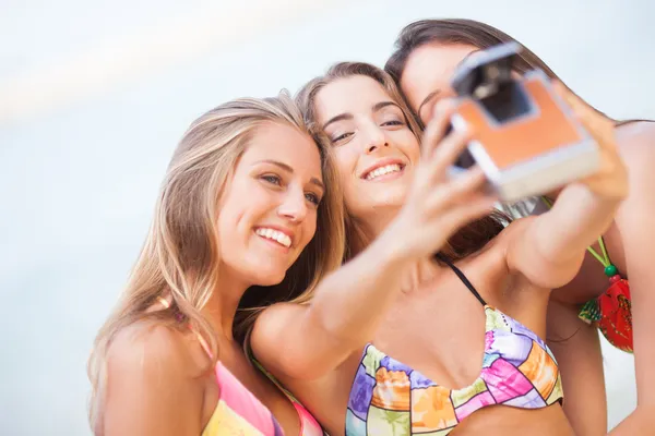 Drei junge schöne Freundinnen haben Spaß am Strand mit einem — Stockfoto
