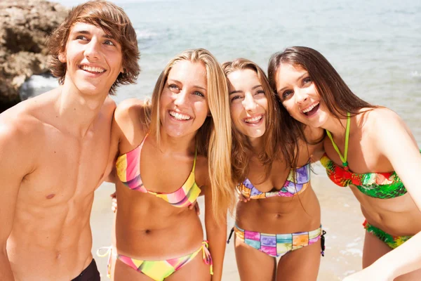 Jóvenes hermosos amigos grupo riendo en la playa —  Fotos de Stock