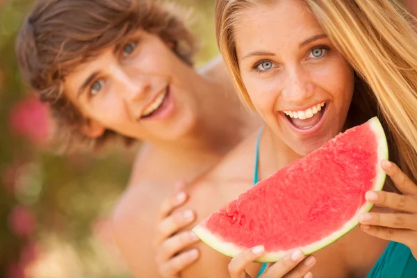 Retrato de una joven pareja hermosa comiendo sandía —  Fotos de Stock