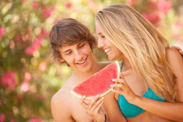 Portrét mladé nádherný pár jíst meloun — Stock fotografie