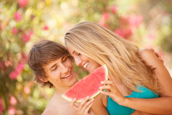Retrato de una joven pareja hermosa comiendo sandía — Foto de Stock