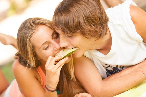 Retrato de una joven hermosa pareja comiendo melón — Foto de Stock