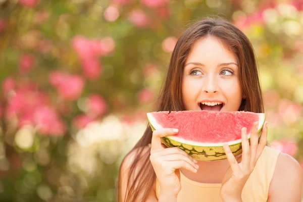 Porträt einer schönen jungen Frau, die Wassermelone isst lizenzfreie Stockbilder